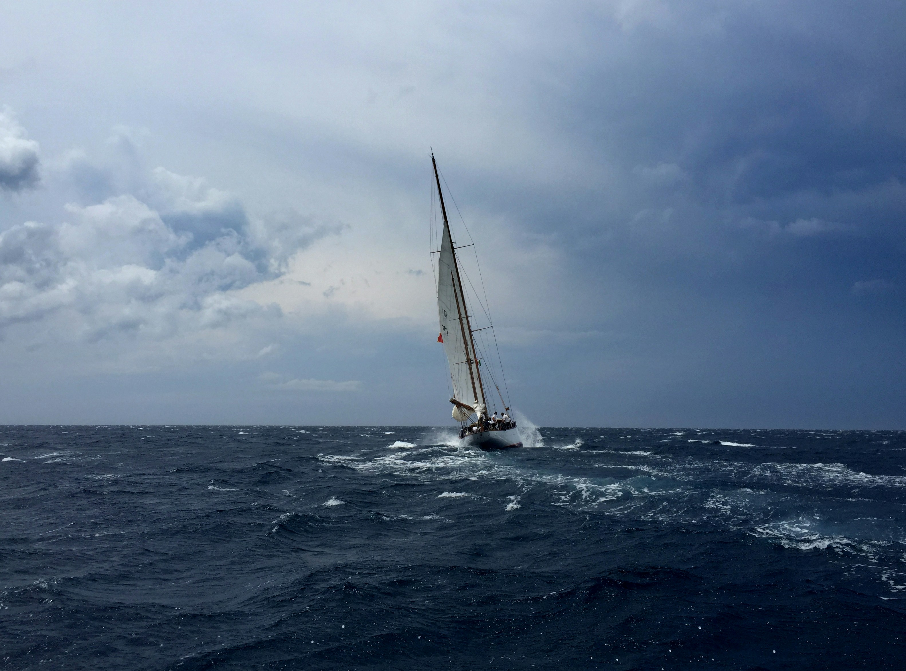 Experienced sailor adjusting sails on a sailboat during an advanced sailing course.